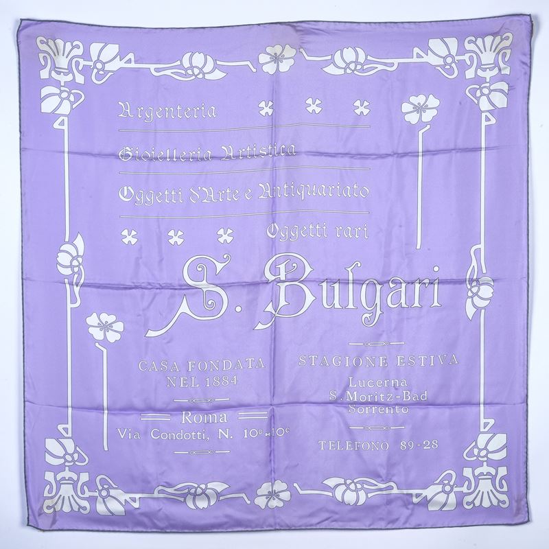 Foulard in seta con scritte e motivo floreale su fondo lilla